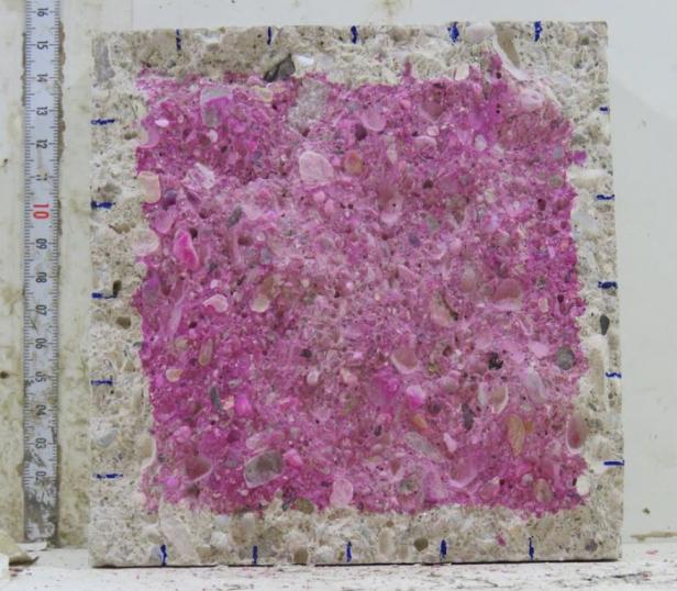 Querschnitt durch einen Betonblock mit lila eingefärbten CO2-Einlagerungen