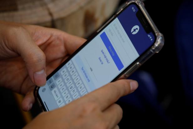 FILE PHOTO: A Facebook user logs in on his mobile at a cafe in Hanoi