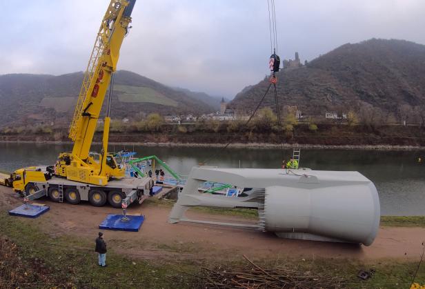 Schwimmende Turbine zur Stromerzeugung in Flüssen an einem mobilen Kran