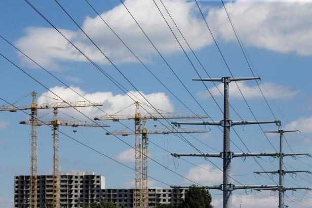 FILE PHOTO: Building cranes and power lines connecting pylons of high-tension electricity are seen in Kyiv