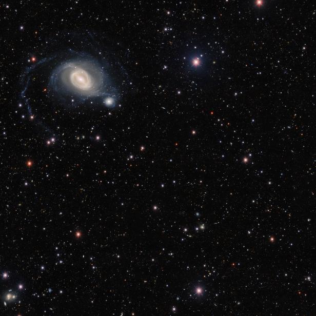 Eine Spiralgalaxie leuchtet inmitten unzähliger Sterne.