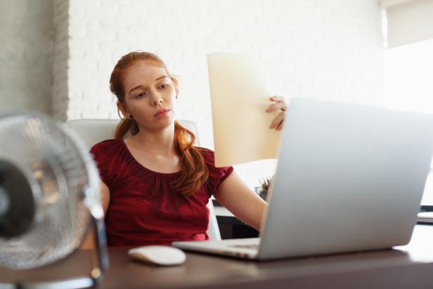 Businesswoman Sweating At Work With Broken Conditioner