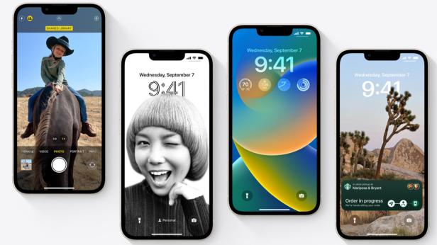 Vier iPhones zeigen verschiedene Hintergründe und Sperrbildschirm-Anpassungen.