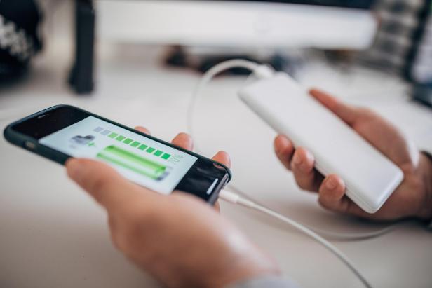 Man charging smart phone on wireless power bank