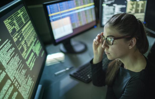 Woman surrounded by monitors