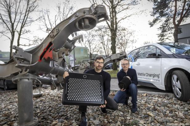 Armin Buchroithner (l.) und Peter Brunnhofer von der TU Graz mit Bodenplatte und Stromabnehmer des Matrix Charging Systems