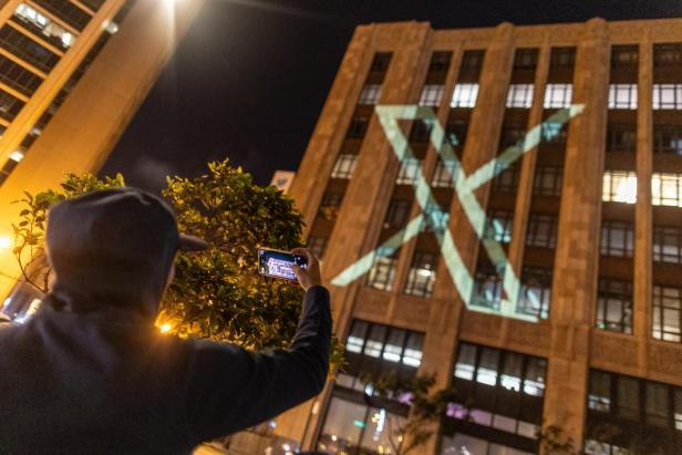 Twitter's new logo is seen projected on the corporate headquarters building in downtown San Francisco, California