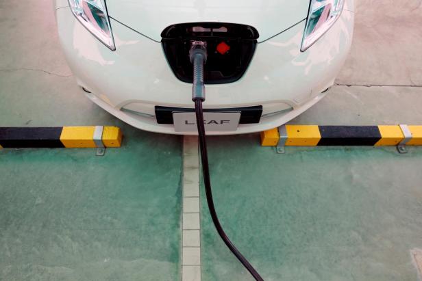 FILE PHOTO: An electric car is seen while being charged during the opening of a PTT Pcl energy firm's commercial EV charging station, in Bangkok