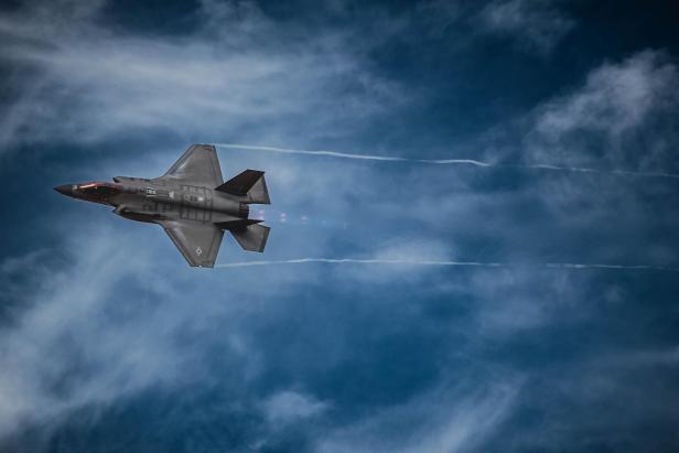 Ein F-35A Kampfjet fliegt am blauen Himmel.