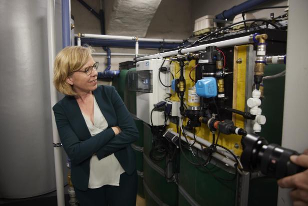 Klimaschutzministerin Leonore Gewessler bewundert die Haustechnik im sanierten Passivhaus Kauergasse 2