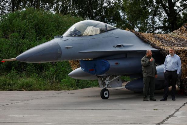 Ukrainian Defence Minister Umerov and Secretary of Ukraine's National Security and Defence Council Lytvynenko stand next to an F-16 fighting aircraft  in an undisclosed location in Ukraine