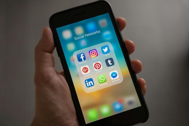 Die EFF rät, sich von Social Media Apps auszuloggen, oder sie ganz vom Smartphone zu löschen (Symbolbild). Eine Hand mit einem Smartphone, auf dem die Icons verschiedener Sozialer Netzwerke angezeigt werden