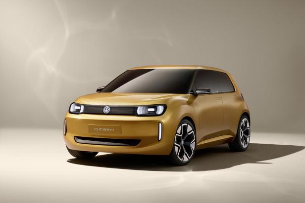 Der goldfarbene Volkswagen ID.Every1 steht vor einem neutralen Hintergrund.