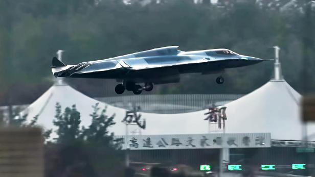 Ein J-36 Kampfflugzeug im Flug über einer Straße.