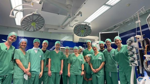 Die beteiligten Studierenden der FH OÖ im Kepler Universitätsklinikum Linz. 14 Personen in OP-Kleidung in einem OP