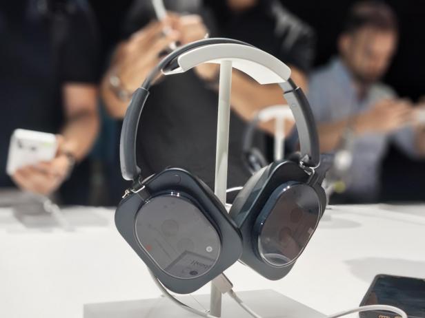 Kopfhörer in Schwarz stehen auf einem weißen Tisch.