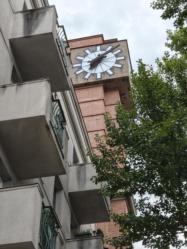 Ein Gebäude mit Balkonen und einer großen Uhr an der Fassade.