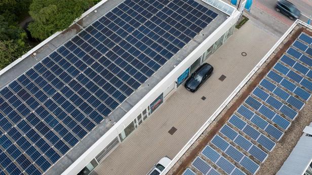 Auf den Dächern eines Gebäudes sind Photovoltaikanlagen installiert.