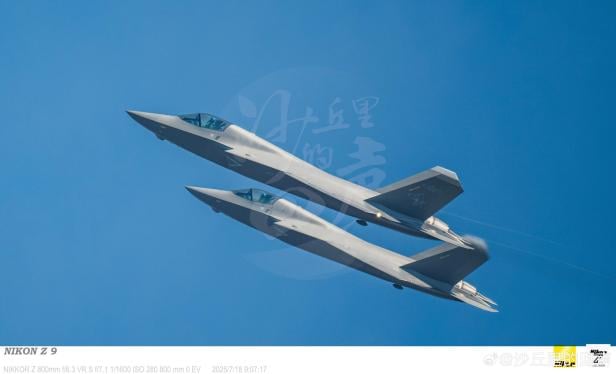 Zwei J-35 Tarnkappenjets fliegen am blauen Himmel.