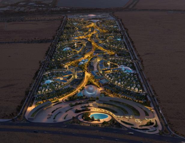 Eine Luftaufnahme der beleuchteten Khalid-Bin-Sultan-Stadt in der Nacht.