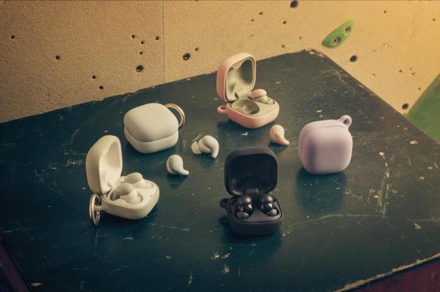 Verschiedenfarbige Sony LinkBuds Fit und Ladeetuis auf einer strukturierten Oberfläche.