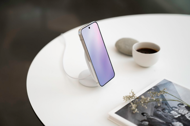 Ein Google Pixel 10 steht auf einer kabellosen Ladestation neben einer Tasse Kaffee.