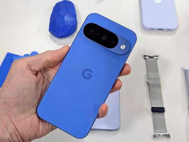 Ein blaues Google Pixel Smartphone wird in der Hand gehalten.
