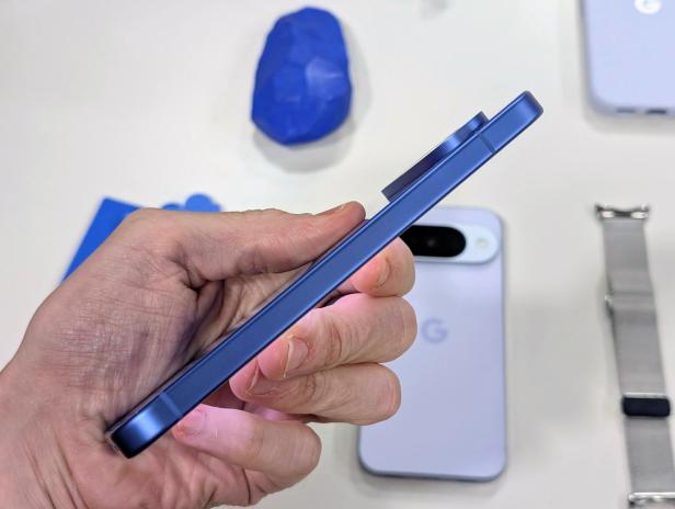 Ein blaues Google Pixel Smartphone wird in der Hand gehalten.