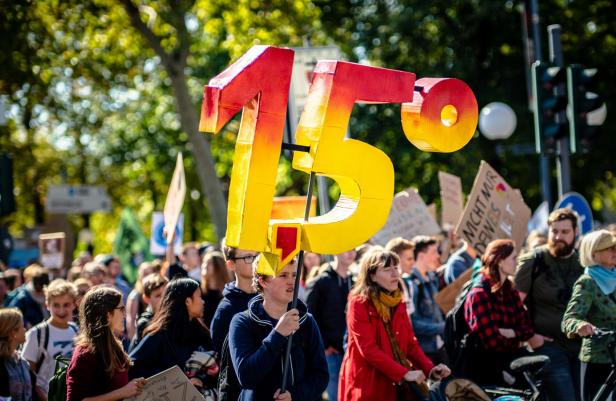 Menschen mit Plakaten bei einer Demo gegen den Klimawandel.