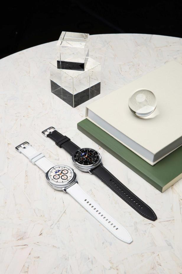 Zwei Samsung Galaxy Watch8 Classic Uhren mit unterschiedlichen Armbändern liegen auf einem Tisch.