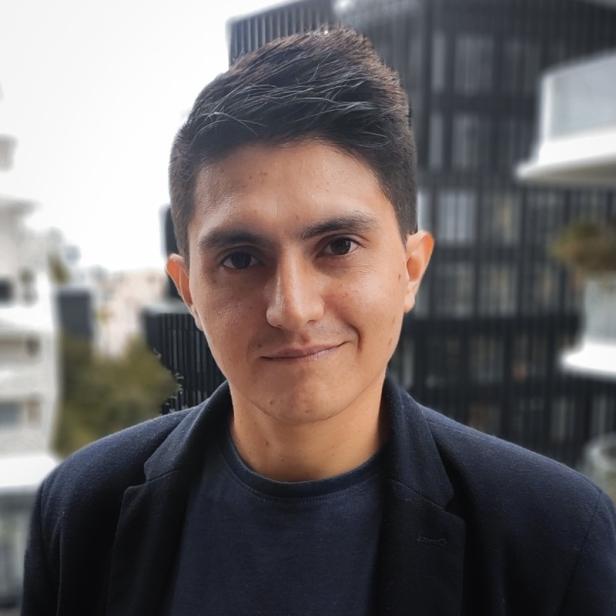 Ein junger Mann lächelt vor einem Gebäude in einer Stadt.