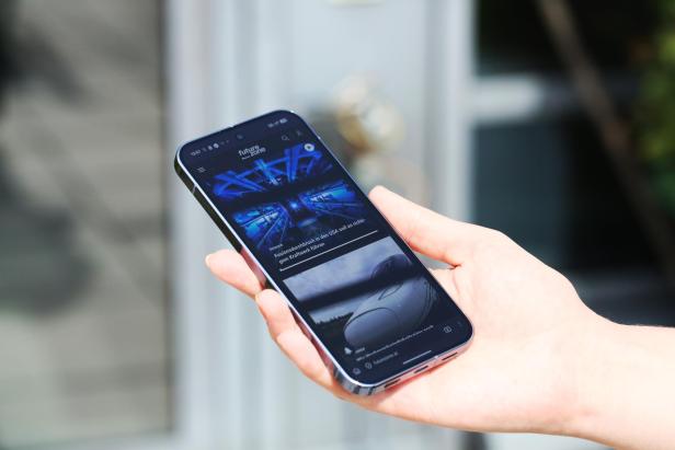 Ein Smartphone mit der Webseite Futurezone in einer Hand.