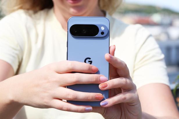 Eine Person hält ein blaues Google Pixel Smartphone in den Händen.