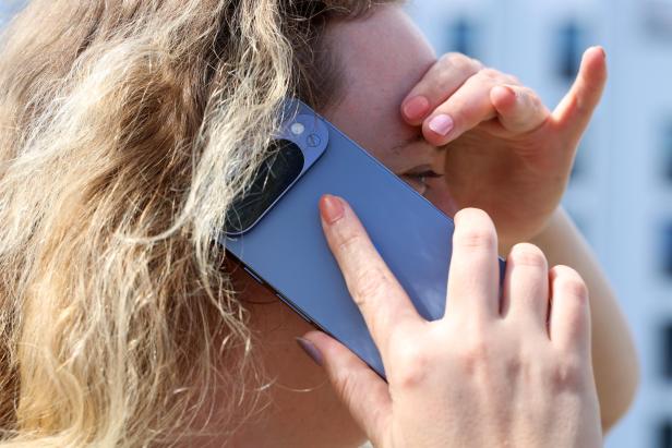 Eine Frau telefoniert mit einem blauen Smartphone.