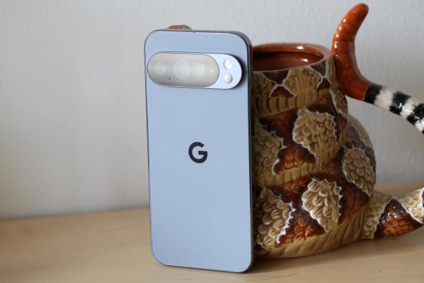 Ein hellblaues Google Pixel-Smartphone steht neben einer Schlangentasse.