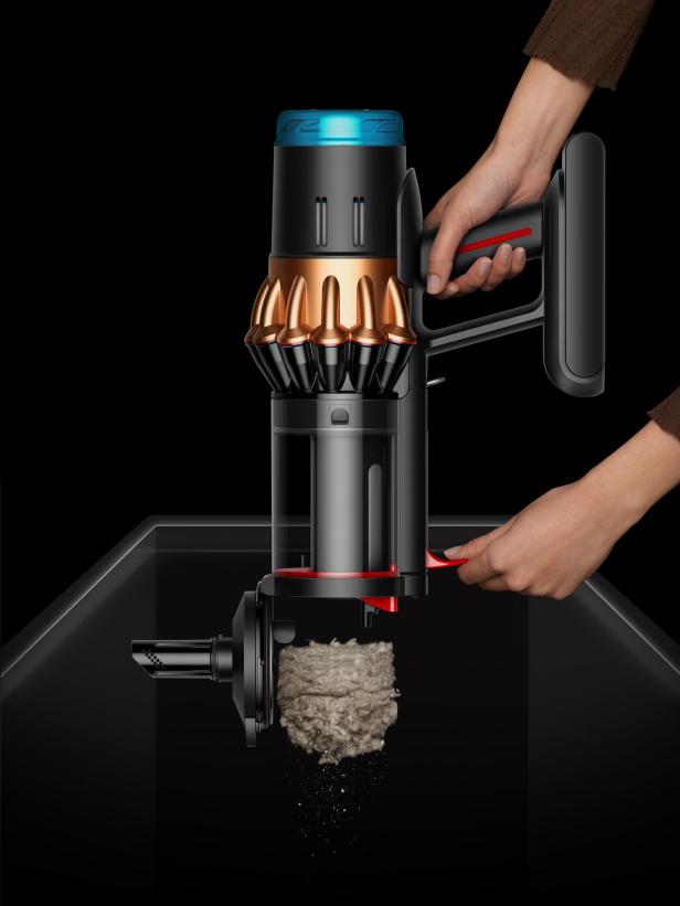 Ein Dyson Staubsauger wird über einem Behälter entleert.