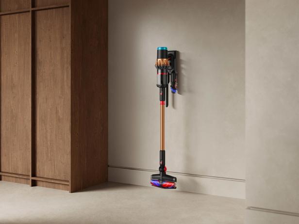 Ein kabelloser Staubsauger von Dyson hängt an einer Wandhalterung.