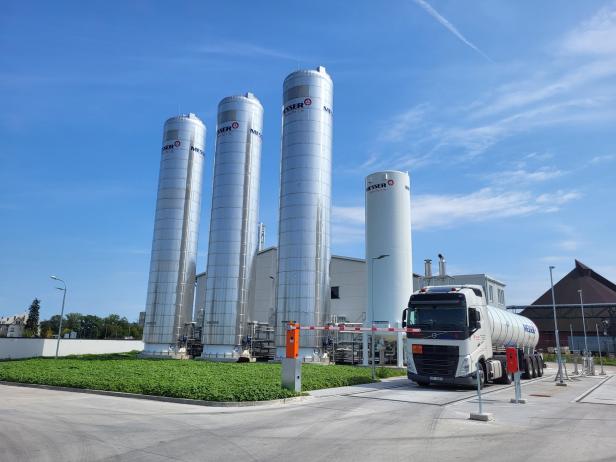 Ein Lastwagen steht vor großen Silos.