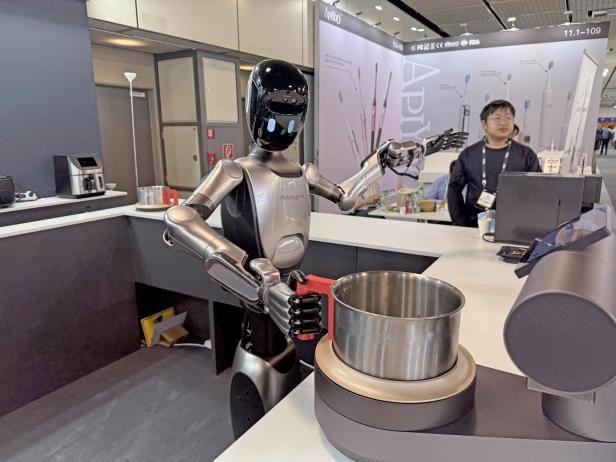 Der Küchenroboter Robbyant hantiert mit einem Topf.