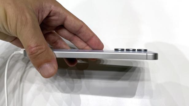 Ein silbernes Samsung Galaxy S25 FE wird von einer Hand gehalten.