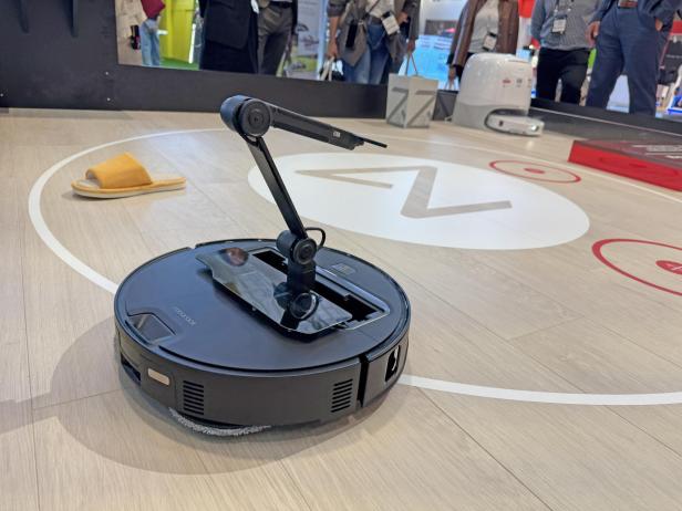 Der Roborock Saros Z70 Saugroboter mit Reinigungsstation auf einem Stand.