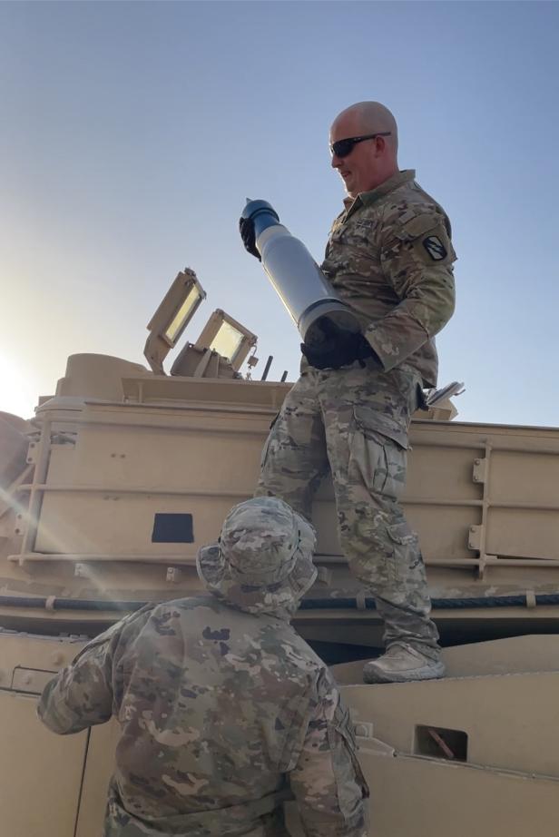 US-Soldaten laden 120mm-Munition in einen M1A1 Abrams.