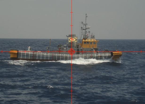 Ein Schiff fährt auf dem Meer, aufgenommen durch ein Zielfernrohr.