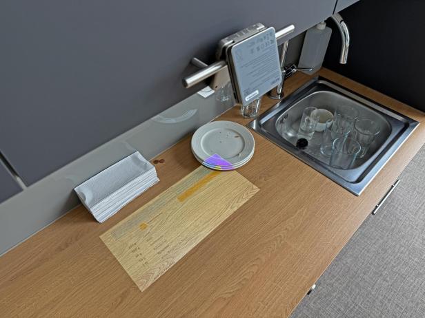 Eine Spüle mit schmutzigem Geschirr und Gläsern auf einer Küchentheke.