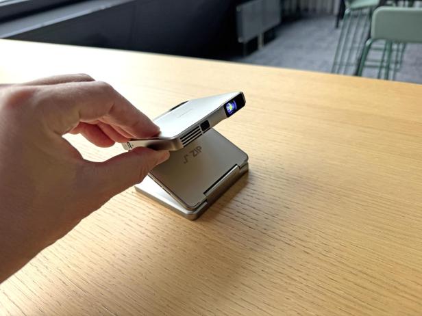 Ein tragbarer ZIP-Projektor wird von einer Hand gehalten.