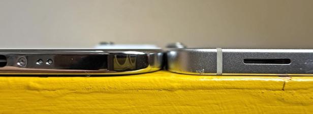 Zwei iPhones liegen nebeneinander auf einer gelben Oberfläche.