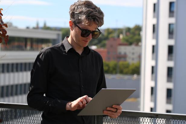 Thomas hält das Boox Tab X C in der Hand.