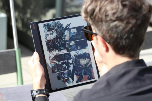 Ein Mann liest einen Comic mit Robotern auf einem Boox Tablet.