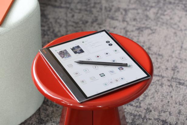 Ein Boox Tab X mit Stift liegt auf einem roten Hocker.