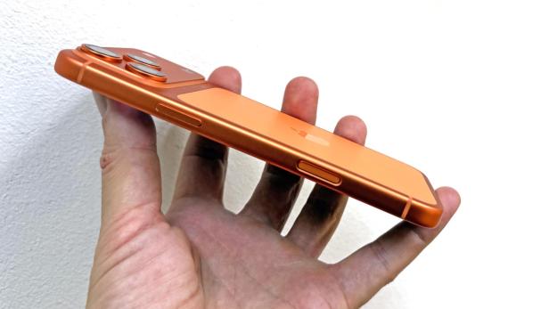 Ein orangefarbenes iPhone 17 Pro Max wird in einer Hand gehalten.